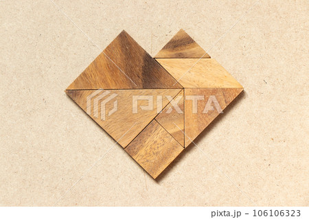 Wooden tangram in heart shape on wood background 106106323