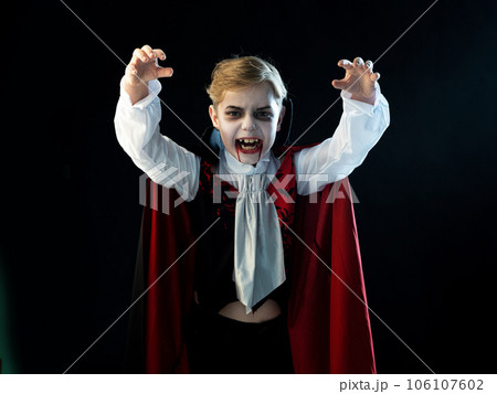 Boy wearing Halloween vampire costume 106107602