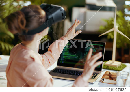 Seen from behind modern female with laptop and vr gear Seen from behind modern female with laptop and vr gear 106107623