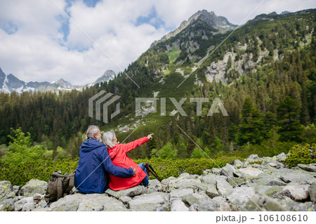 Rear view of senior couple resting during hike in autumn mountains. Rear view of senior couple resting during hike in autumn mountains. 106108610