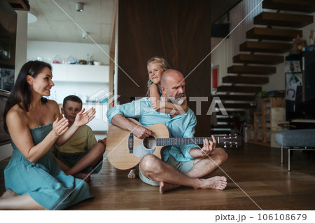 Father playing on guitar for his family. Father playing on guitar for his family. 106108679