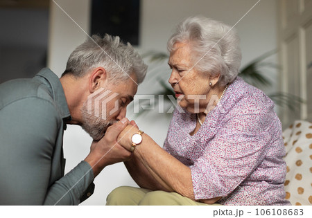 Portrait of mature man kissing his mothers hands. 106108683