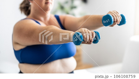 Close-up view of fat woman holding dumbbells. Woman diet weight loss overweight problem concept. 106108759