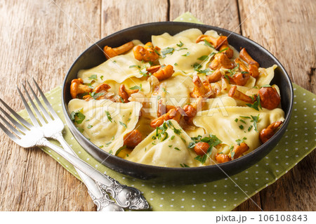 Portion of pasta triangoli stuffed with chanterelle mushrooms, onions and herbs close-up in a plate. Horizontal 106108843