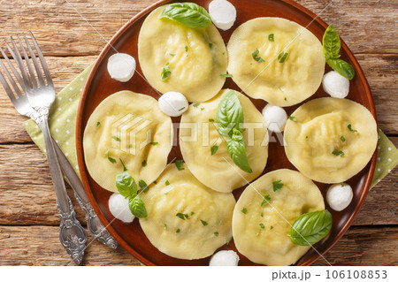 Authentic italian dumplings pasta cappellacci friarielli with mozzarella and herbs close-up in a plate. Horizontal top view Authentic italian dumplings pasta cappellacci friarielli with mozzarella and herbs close-up in a plate. Horizontal top view 106108853