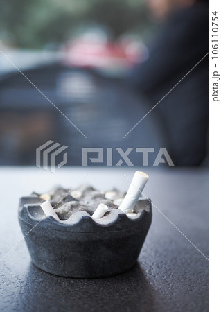 Close up burning cigarette in ashtray on table  106110754