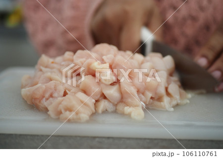 cutting chicken fillet at cooking classes. 106110761