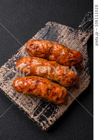 Delicious juicy grilled sausages with salt, spices and herbs 106111028
