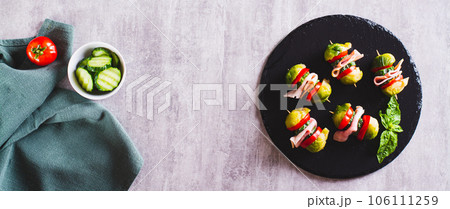 Appetizing sliders with vegetables and ham on a slate board top view web banner Appetizing sliders with vegetables and ham on a slate board top view web banner 106111259