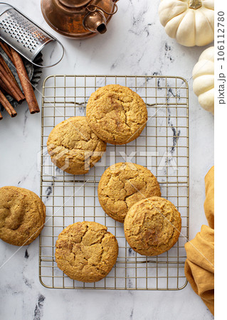 Soft pumpkin cookies on a cooling rack, fall baking 106112780