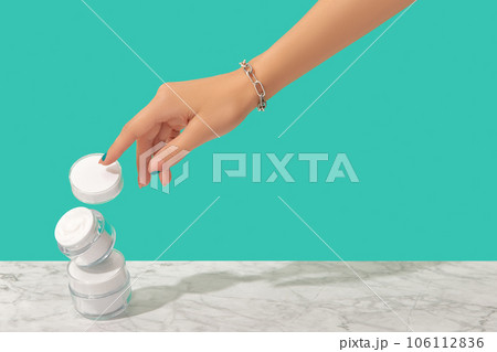 Womans hand touch white jars on turquoise background Womans hand touch white jars on turquoise background 106112836
