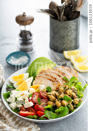Healthy grilled chicken lunch bowl with chickpeas and feta 106113019