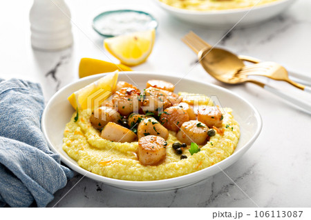 Seared scallops with grits and lemon sauce Seared scallops with grits and lemon sauce 106113087