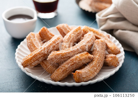 Homemade churros with cinnamon sugar on a plate 106113250