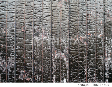 Burned painted red wood on the side on a old rail car 106113305