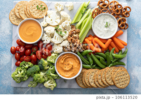 Plant based snack board with vegetables and crackers Plant based snack board with vegetables and crackers 106113520