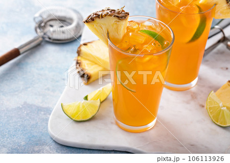 Pineapple rum cocktail with lime slices, refreshing summer cocktail Pineapple rum cocktail with lime slices, refreshing summer cocktail 106113926