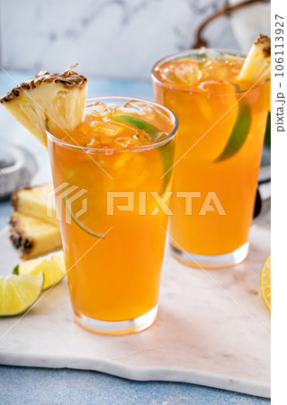 Pineapple rum cocktail with lime slices, refreshing summer cocktail Pineapple rum cocktail with lime slices, refreshing summer cocktail 106113927