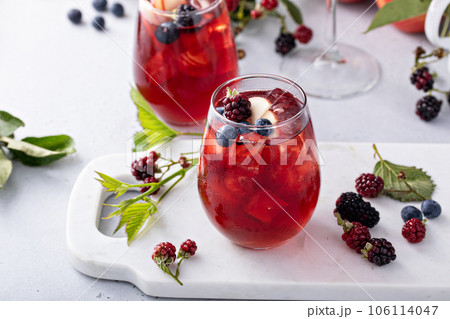 Fall berry and apple sangria in a glass with ice Fall berry and apple sangria in a glass with ice 106114047