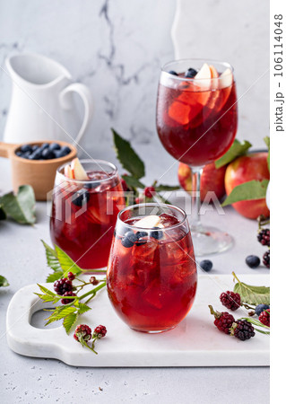 Fall berry and apple sangria in a glass with ice Fall berry and apple sangria in a glass with ice 106114048