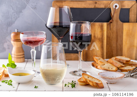 Variety of wine glasses with red, white and rose wine 106114196