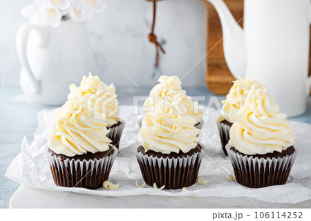 Chocolate cupcakes topped with cream cheese frosting 106114252
