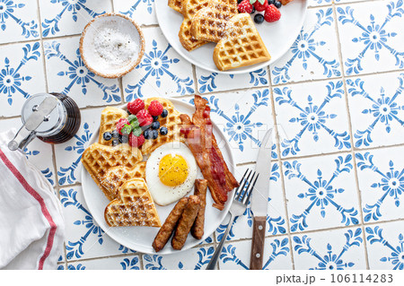 Breakfast table with waffles. fried egg, bacon and sausage 106114283