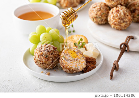 Cheese balls or truffles on a cheese board with crackers Cheese balls or truffles on a cheese board with crackers 106114286