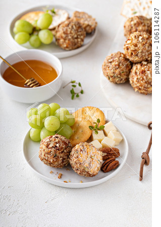 Cheese balls or truffles on a cheese board with crackers Cheese balls or truffles on a cheese board with crackers 106114287