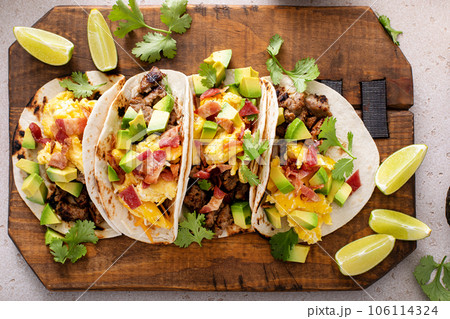 Breakfast tacos with sausage, eggs, bacon and avocado Breakfast tacos with sausage, eggs, bacon and avocado 106114324
