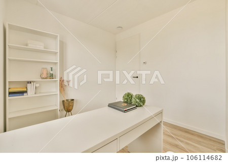 an office space with white walls and wooden flooring the room is well lit by natural light from the windows an office space with white walls and wooden flooring the room is well lit by natural light from the windows 106114682