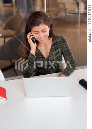 Cheerful working lady speaking on phone Cheerful working lady speaking on phone 106115018