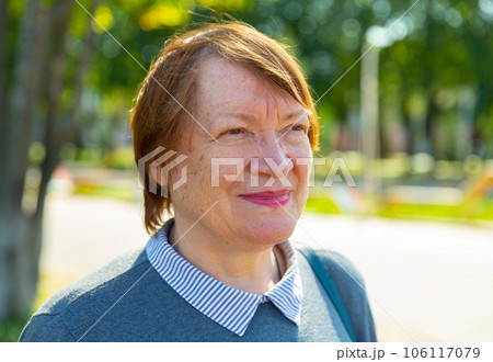 Smiling mature lady in urban park Smiling mature lady in urban park 106117079
