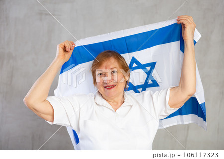 Happy senior woman waving national flag of Israel Happy senior woman waving national flag of Israel 106117323