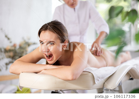 Young female client dissatisfied with work of masseuse Young female client dissatisfied with work of masseuse 106117336