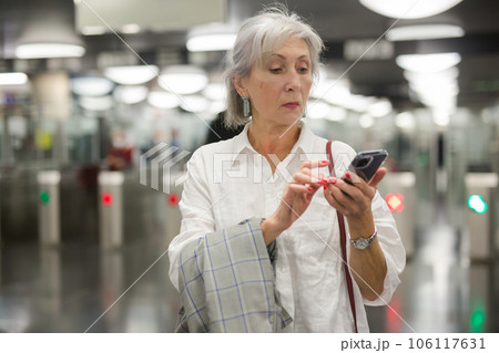 Caucasian woman with smartphone in subway station Caucasian woman with smartphone in subway station 106117631