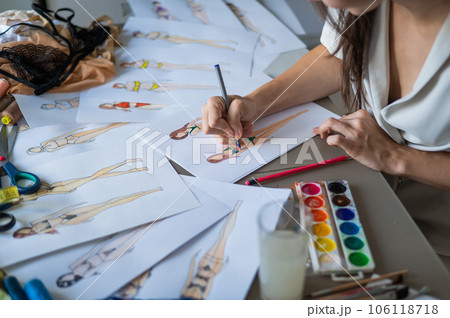 Faceless woman draws sketches of swimwear. Close-up of the hands of a fashion designer. Faceless woman draws sketches of swimwear. Close-up of the hands of a fashion designer. 106118718