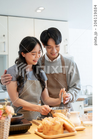 A lovely Asian couple having a cooking date at home, and enjoying making pancakes in the kitchen. A lovely Asian couple having a cooking date at home, and enjoying making pancakes in the kitchen. 106119884