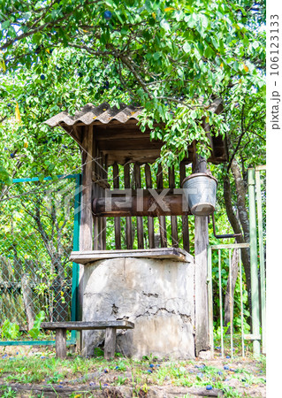 Old well with iron bucket on long forged chain for clean drinking water Old well with iron bucket on long forged chain for clean drinking water 106123133