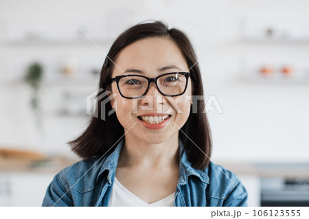 Asian woman in glasses posing at home in kitchen interior Asian woman in glasses posing at home in kitchen interior 106123555