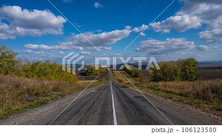 Road landscape. Empty track among mountains and fields in autumn. Road landscape. Empty track among mountains and fields in autumn. 106123580