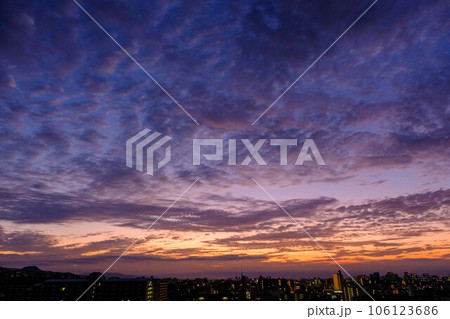 都市の夜明け。東の空が明るくなり雲がまだ昇る前の太陽に照らせら美しいグラデーションを見せる。神戸市内 106123686