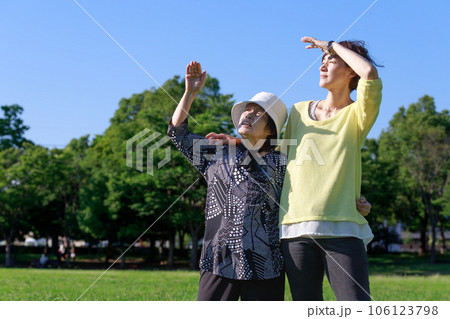 紫外線と太陽光がまぶしいシニアの女性と支える娘 106123798