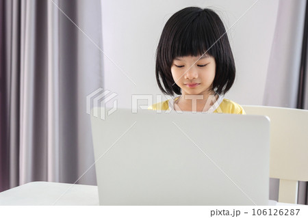 little asian girl student study online using laptop computer at home 106126287