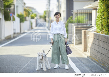 愛犬のワイヤーフォックステリアと住宅街を散歩する若い女性 106127327
