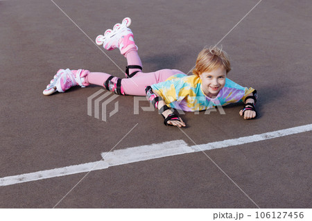 A little girl fell on roller skates. Learns to ride. 106127456