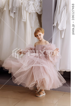 Girl in a lush pink evening dress in a clothing boutique 106127468
