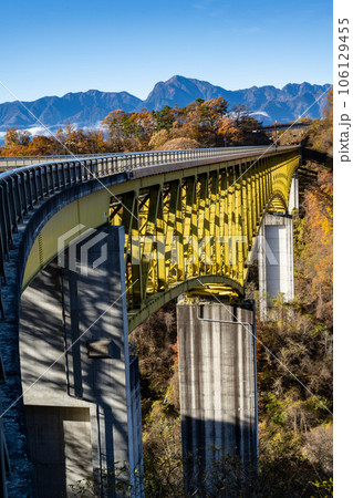 秋空に照らされた陸橋と紅葉 106129455