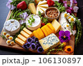 top view of a cheese platter with fresh herbs and edible flowers 106130897