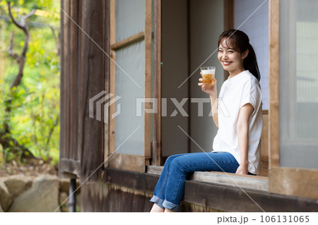 縁側でビールを飲む女性 106131065